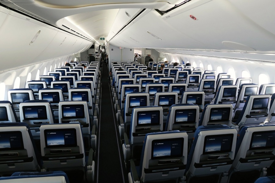 Rows of economy seats with seat-back screens in a Lufthansa Boeing 787-9