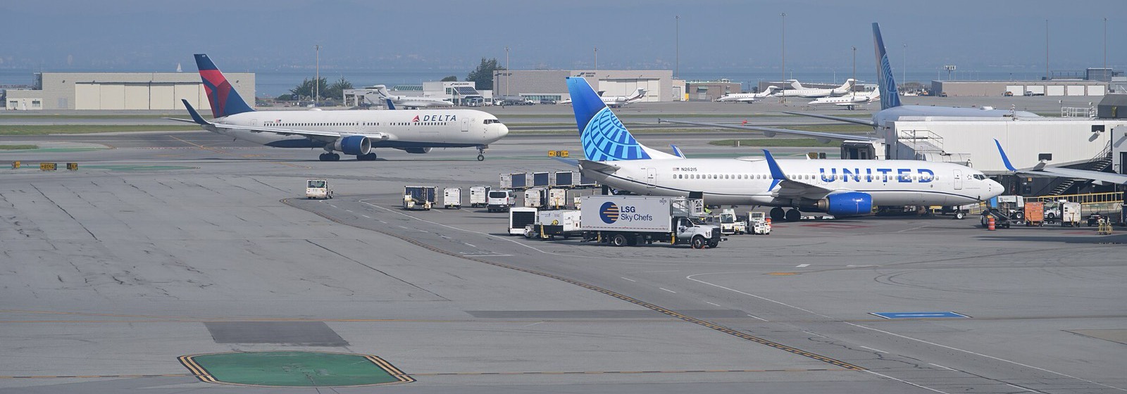 A Delta Boeing 767 taxiing past a United Boeing 737 at a gate at San Francisco International Airport